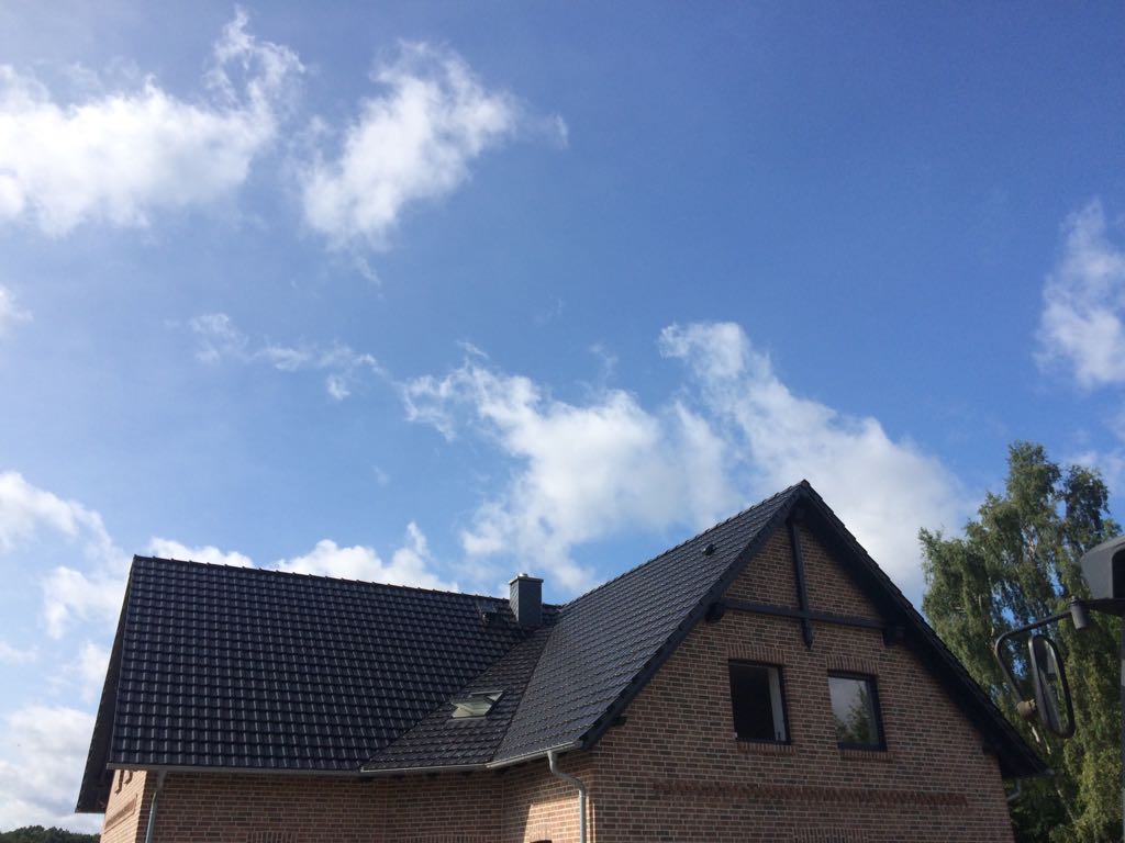 Saniertes Steildach mit dunkler Eindeckung und Dachfenster